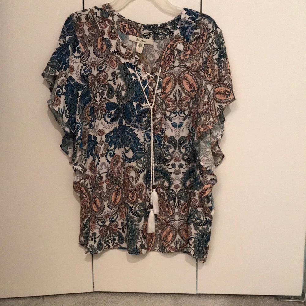 Blouse with floral design and tassels.